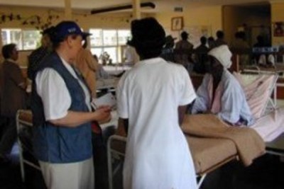 Nurses attending to patients in a hospital ward.