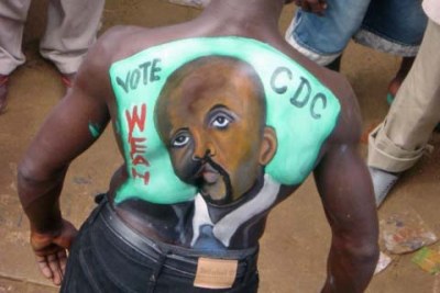 A George Weah fan paints the former soccer star image on his back.