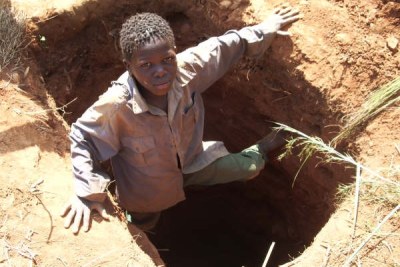 Photo Archive - Sidio Elias, 12 ans, sort du puits de mine qu'il a creusé avec deux autres enfants.