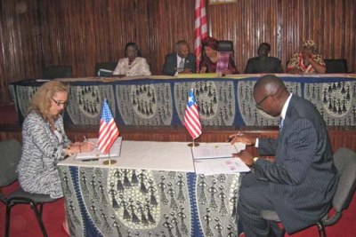 Liberia Finance Minister Amara Konneh signs for a U.S.$15 million MCC grant in 2010.