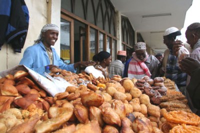 Omar Ramadhan,left sells snacks to musilms outside a mosque. The snacks are usually taken by the muslim faithful the marking of the holy month of Ramadhan.
