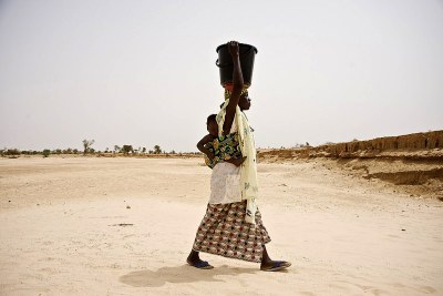 Zalika Mounkaila (51) carries water back to the village.