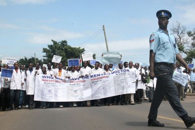 A police officer walks past demonstrating public hospital doctors (file photo)