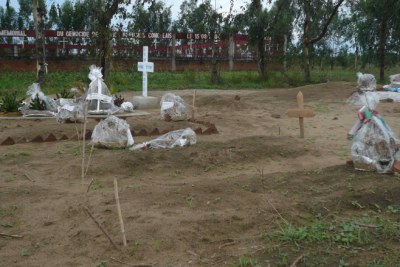 Tombes de victimes de l'attaque du 18 septembre 2011 à Gatumba au premier plan, et mémorial pour les victimes de l'attaque de 2004 à Gatumba