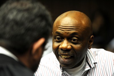 Nigerian Henry Okah, found guilty of masterminding two car bomb blasts in Abuja, Nigeria, speaks to his legal representative at the High Court in Johannesburg, South Africa. (file photo)