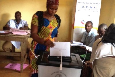 Cette électrice glisse son bulletin de vote dans l'urne... «A voté!»