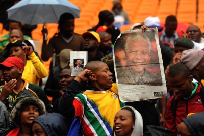 Mourners attend a Nelson Mandela memorial service at the FNB stadium on Tuesday, 10 December 2013.