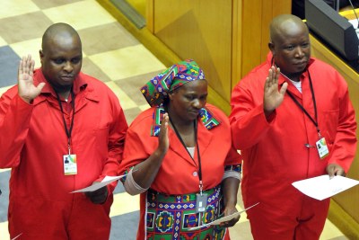 Economic Freedom Fighters leader Julius Malema, right, takes the Oath of Office wearing red workers' overalls along with other members of his party (file photo).
