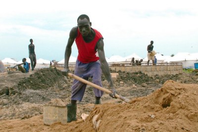 A man shovels sand for a waste-water treatment facility within the new IDP camp at the UN base in Malakal, South Sudan.