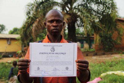Saa Sabas Temessadouno, 48, displays his Ebola-free certificate after surviving the disease.