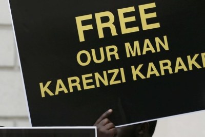 Protesters hold placards demanding the release of Rwanda's intelligence chief Karenzi Karake outside Westminster Magistrate's Court in London.