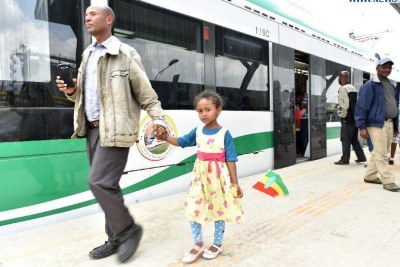 Local residents walk on the platform of a light rail station in Addis Ababa, Ethiopia.
