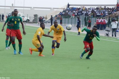 Rwanda forwards Isaie Songa and Innocent Habyarimana sprint for the ball as Cameroon defenders mark them during a match at Umuganda stadium.