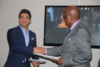 ZIFA president Philip Chiyangwa (right) and Total Sports Marketing chief executive Moinul Chowdury exchange documents after the signing of  a deal in Harare.
