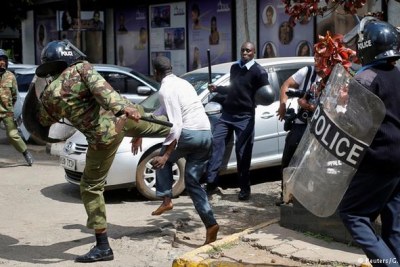 Policemen beats a protester during clashes in Nairobi on May 16, 2016.