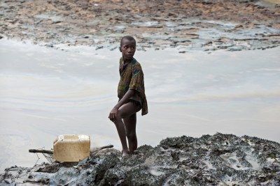 Child standing at oil-polluted river banks (file photo).