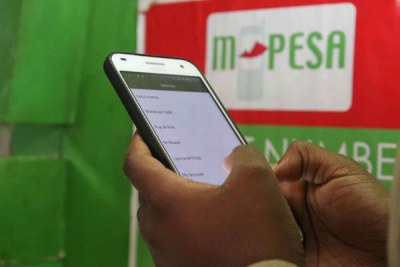 A mobile phone user withdraws money from their M-Pesa account.