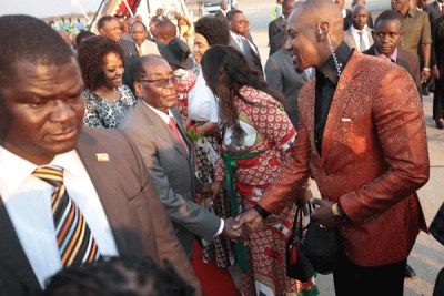 President Robert Mugabe greets his son-in-law, Simba Chikore at Harare International Airport (file photo).