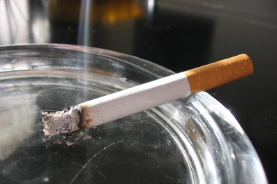 A lit cigarette in an ashtray.