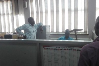 Charles Etukuri, left,  back in office after being released.