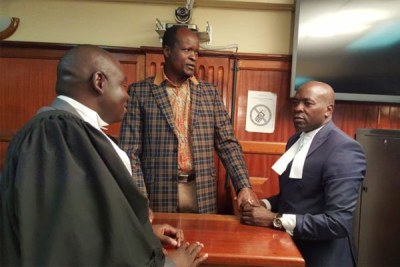 Migori Governor Okoth Obado speaks with his lawyers at the High Court in Nairobi on October 12, 2018.