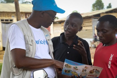 Le 12 septembre 2018 à Beni, un membre du personnel de l'UNICEF discute du meilleur moyen de se protéger contrel' Ebola, lors d'une conversation avec des jeunes vivant à Beni, en République démocratique du Congo, après une récente épidémie d'Ebola.
