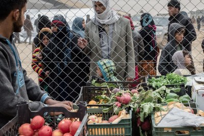 Un marchant ambulant vend des produits alimentaires à l'extérieur d'un camp pour personnes déplacées