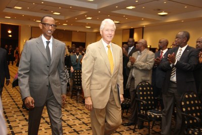 Rwandan President Paul Kagame and United States President Bill Clinton arrive to give a joint statement on the Nutrition Initiative in Kigali in 2013.