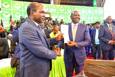 Wafula Chebukati chair of the Independent Electoral and Boundaries Commission (IEBC) presenting a certificate of election to William Ruto, after he was was declared winner of the Presidential contest by the IEBC.