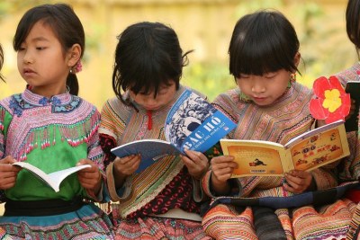 Des fillettes d'une communauté autochtone lisent dans la cour de l'école primaire Ban Pho, dans la province de Lao Cai, au Viet Nam.