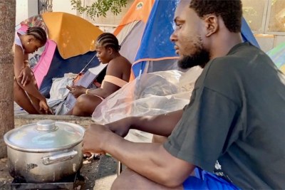 Joseph Milk, originaire du Libéria, prépare un repas avec ses compatriotes migrants à Tunis.