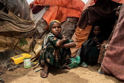 Une jeune fille est assise devant la tente dans laquelle vit sa famille dans un camp pour personnes déplacées à Mogadiscio, en Somalie, en octobre 2022.
